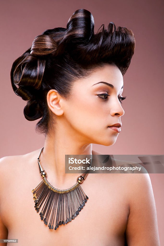 Nude women wearing a necklace and hair tied up Hair concept of a mixed race woman with green eyes and a creative sleek and shiny updo. The beautiful woman is of african american and middle eastern descent. Women Stock Photo