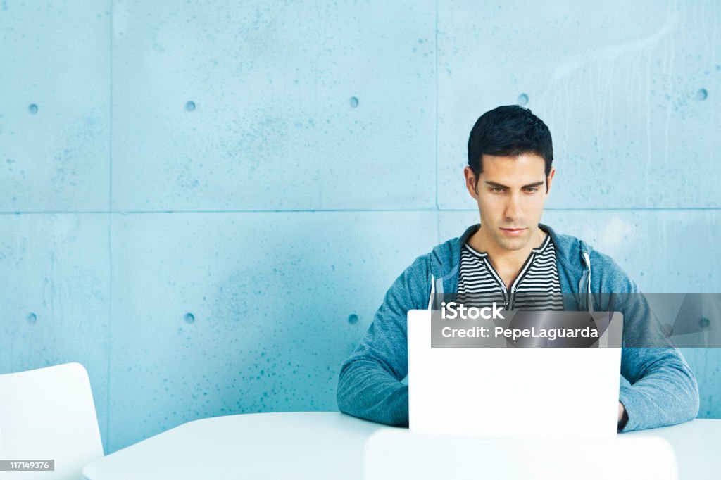 Young casual man using laptop Young casual man using laptop in a modern office. Laptop Stock Photo