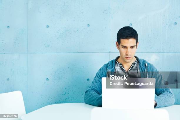 Young Casual Man Using Laptop Stock Photo - Download Image Now - Laptop, Sparse, Casual Clothing