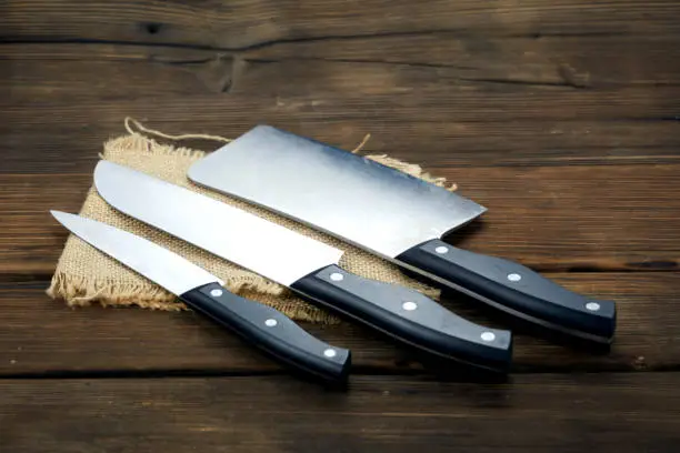 Photo of knife isolated on wood background.