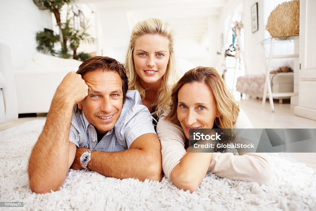 Atractiva family lying on carpet - Foto de stock de 20 a 29 años libre de derechos