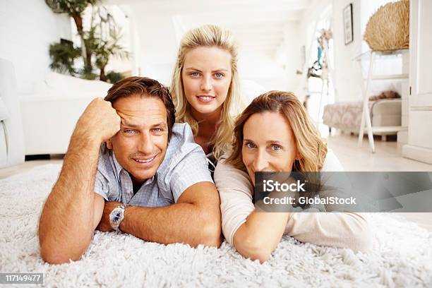 Atractiva Family Lying On Carpet Foto de stock y más banco de imágenes de 20 a 29 años - 20 a 29 años, 40-49 años, Acostado