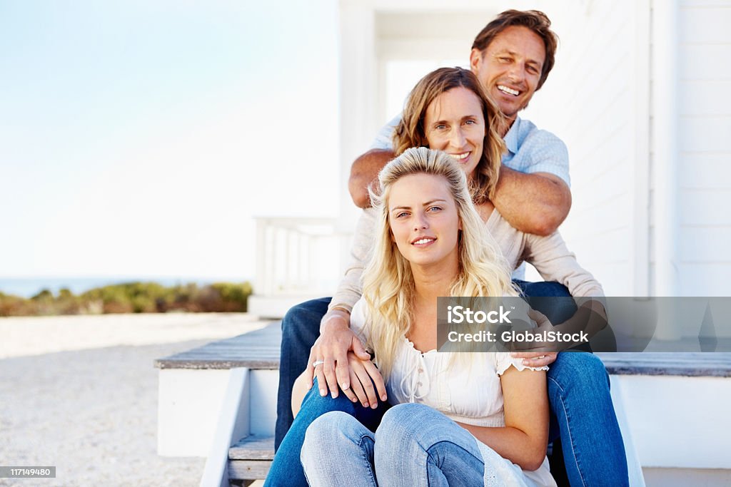 Família sentado ao ar livre em frente da casa - Foto de stock de 20 Anos royalty-free