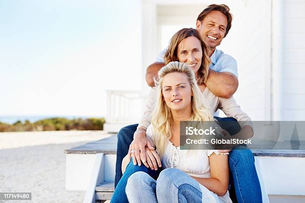 Foto de Família Sentado Ao Ar Livre Em Frente Da Casa e mais fotos de stock de 20 Anos - 20 Anos, 30 Anos, 40-49 anos