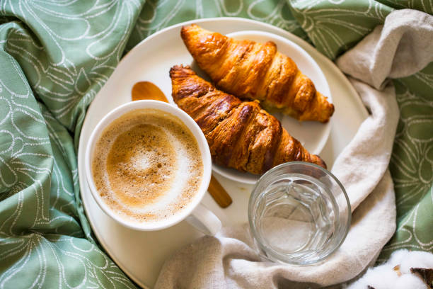istock Morning breakfast with coffee cup and croissants in bed. Top view 1171494859