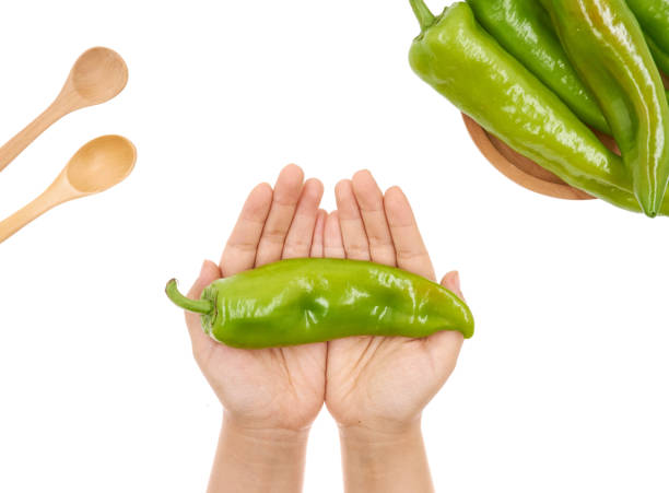 istock Female hand holding Fresh green pepper on white background 1171495165