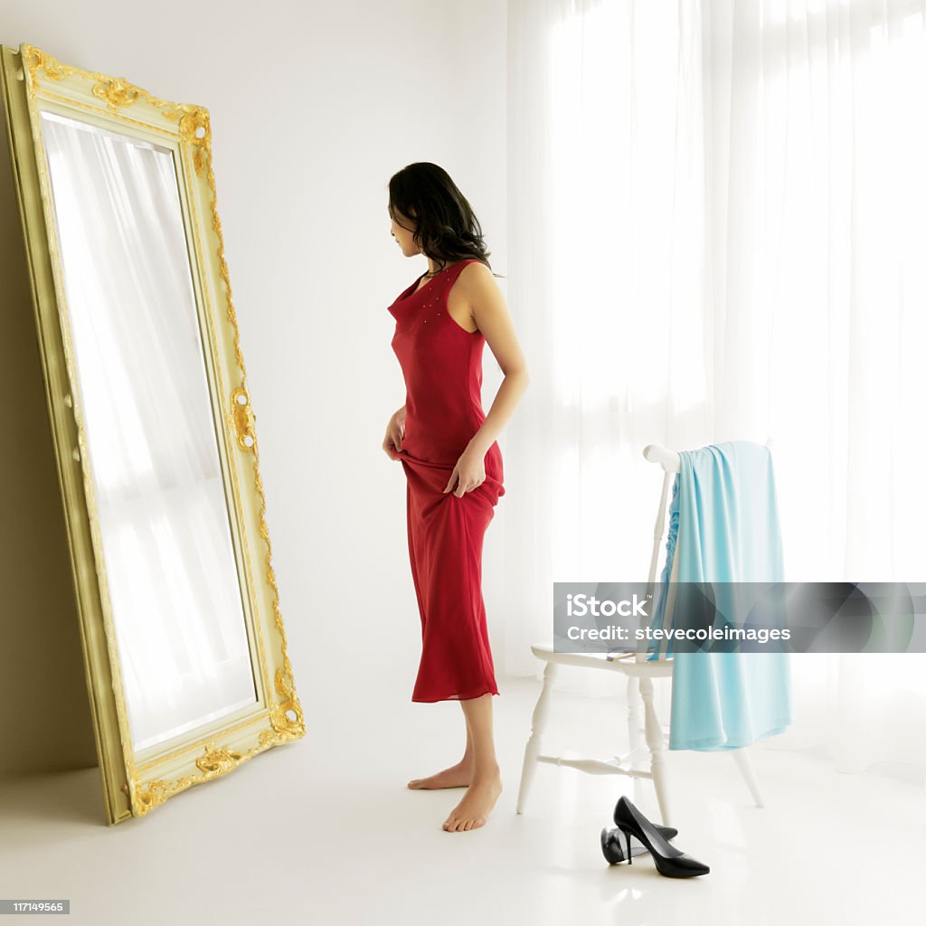 Femme essayer des vêtements de soirée - Photo de Miroir libre de droits