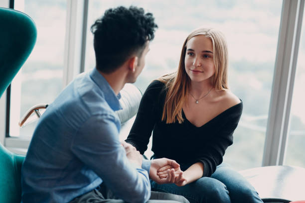 istock Young man holds a woman's hands and looks into her eyes 1171496193