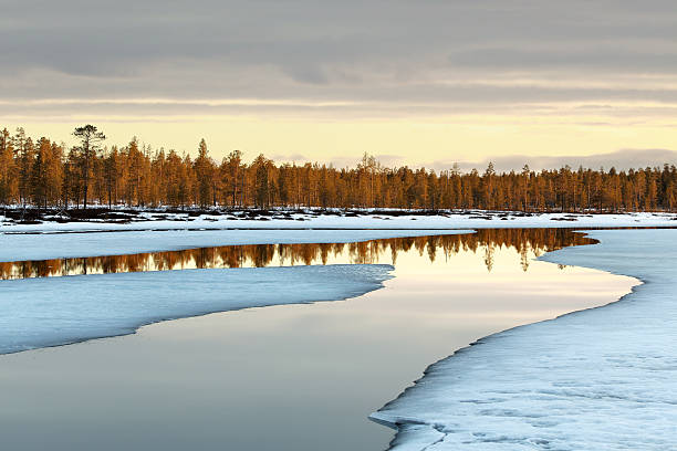 northern spring sunset Melting ice, reflections, wonderful colors & clouds, northern spring, location: Finnish Lapland, near to Inari. snow river stock pictures, royalty-free photos & images