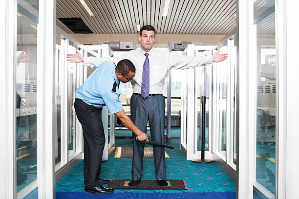 Airport Security Check with Young Businessman Young businessman annoyed with airport security check. metal detector security stock pictures, royalty-free photos & images