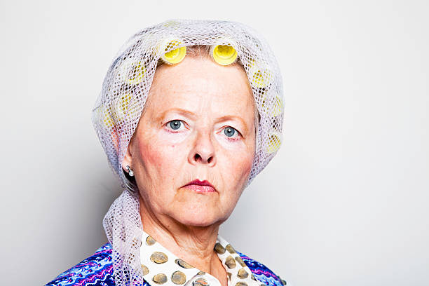 senior woman with curlesr an old ashioned coat, with serious expession