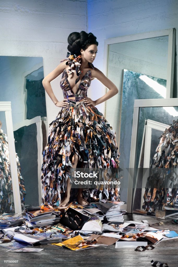 African American Young Woman Fashion Model in Paper Gown Beautiful young woman modeling a paper gown standing on a pile of magazines, surrounded by mirrors. All logos and recognizable faces have been altered. CLICK FOR SIMILAR IMAGES AND LIGHTBOX WITH MORE BEAUTIFUL WOMEN. http://www.quavondo.com/thumbs/IStockLightboxWomen.jpg Haute Couture Stock Photo