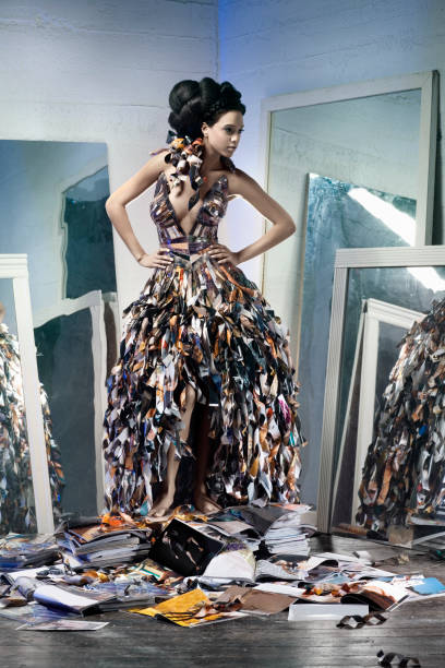 African American Young Woman Fashion Model in Paper Gown Beautiful young woman modeling a paper gown standing on a pile of magazines, surrounded by mirrors. All logos and recognizable faces have been altered. CLICK FOR SIMILAR IMAGES AND LIGHTBOX WITH MORE BEAUTIFUL WOMEN. http://www.quavondo.com/thumbs/IStockLightboxWomen.jpg haute couture stock pictures, royalty-free photos & images