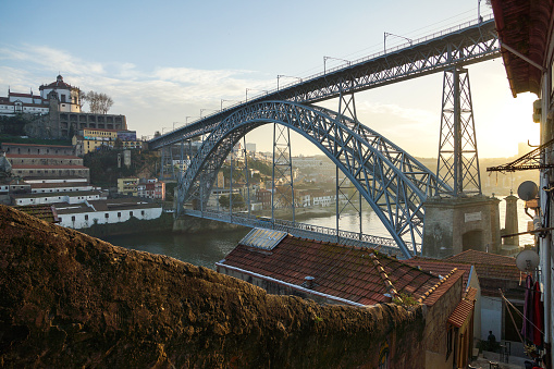 View to the old city of Porto with the D. Luis bridge and colorful buildings at sunset