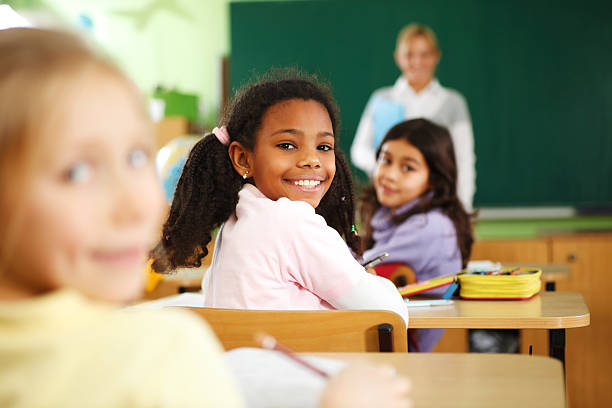 istock School girl looking behind and smiling. 117150439