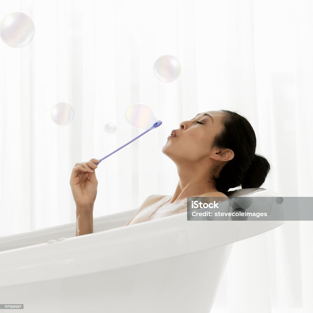 Mujer Soplando burbujas en la bañera - Foto de stock de Baño de espuma libre de derechos