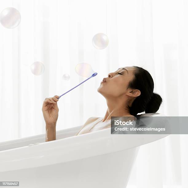 Mujer Soplando Burbujas En La Bañera Foto de stock y más banco de imágenes de Baño de espuma - Baño de espuma, Mujeres, Desnudo