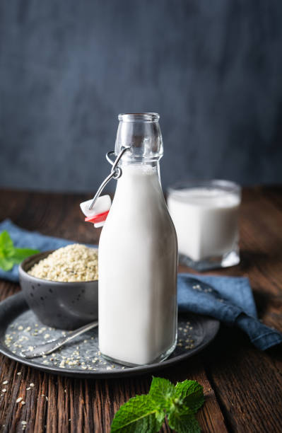 бутылка свежеприготовленного молочного бесплатного молока семян конопли для веганов, украшенного мятой - sieved стоковые фото и изображения