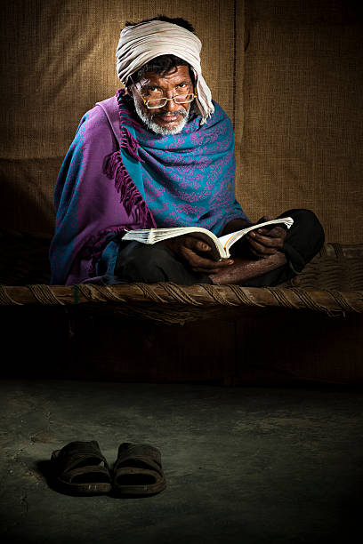 istock Senior, bespectacled, rural Indian man reading a book 117150573