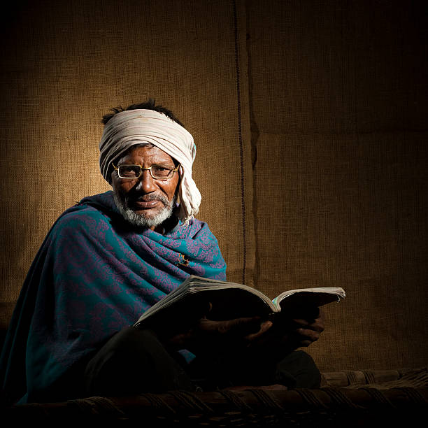 istock Senior, bespectacled, rural Indian man reading a book 117150577