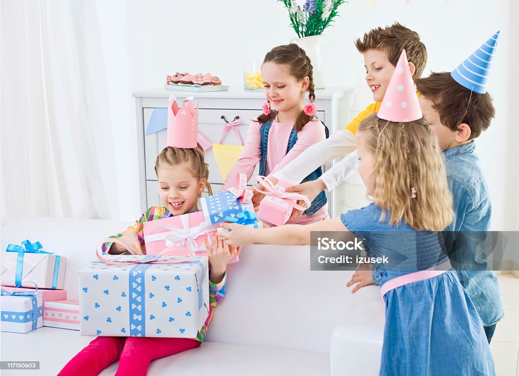 Kids birthday party Four cute kids coming to their girlfriend at birthday party and giving to her many presents. Birthday Candle Stock Photo