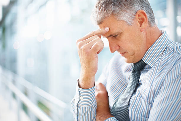 istock A man pinching his forehead indicating a headache 117150639