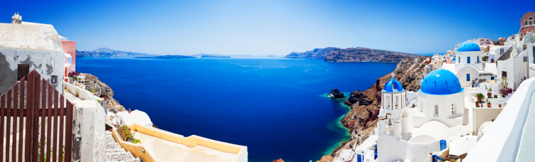 Panorama of Santorini caldera with famous Orthodox churches with blue domes in village Oia (Ia). XXXL wide panorama, stitched from 8 images Canon 5DMkII. Click for more images: http://santoriniphoto.com/Template-Greek.jpg