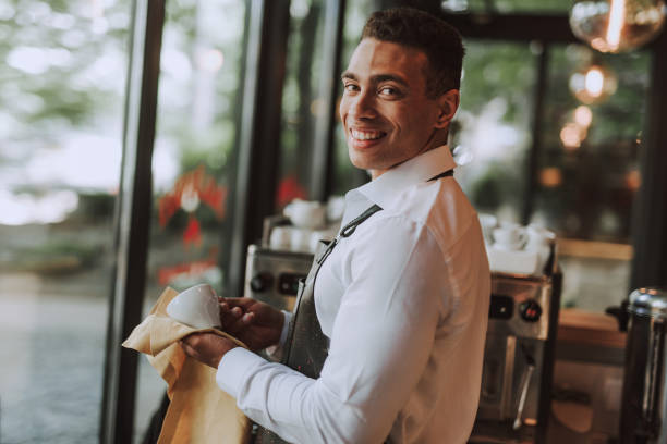 istock Cheerful bartender wiping cup with cleaning cloth 1171507877