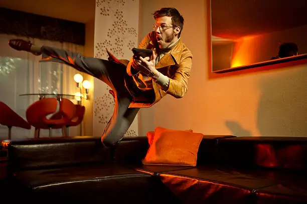 Photo of Retro Secret Agent Man Diving Over Couch