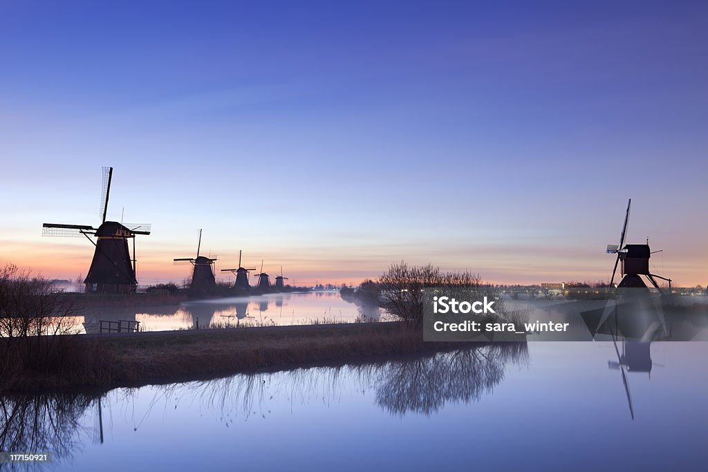 Molinos de viento tradicionales en sunrise, Kinderdijk, los Países Bajos - Foto de stock de Kinderdijk libre de derechos