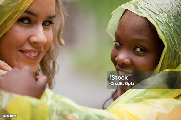 Two Friends In Raincoats Smiling Stock Photo - Download Image Now - 20-24 Years, 20-29 Years, Adult