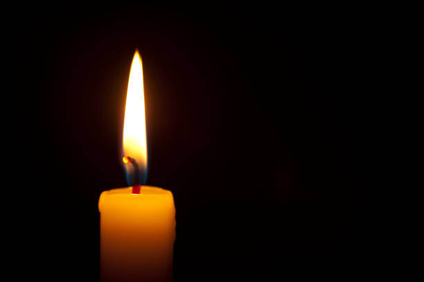 istock Close-up of Single Burning Candle on Black Background 1171510540