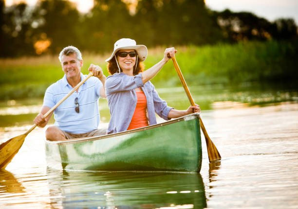 couple d'âge mûr dans un style de vie sain en plein air - canoeing photos et images de collection