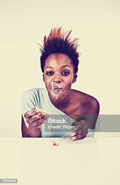 Negro Joven Mujer Comiendo Torta Bajo Techo Vertical Foto de stock y más banco de imágenes de 20 a 29 años