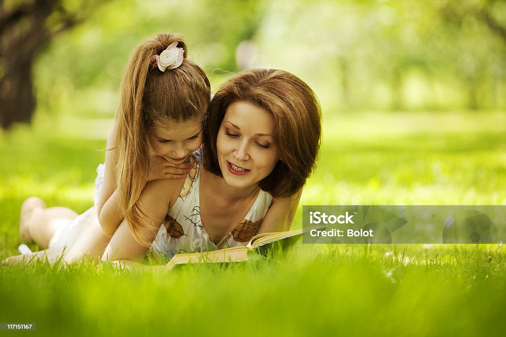 Matka i córka czytać książki w parku - Zbiór zdjęć royalty-free (Trawa)