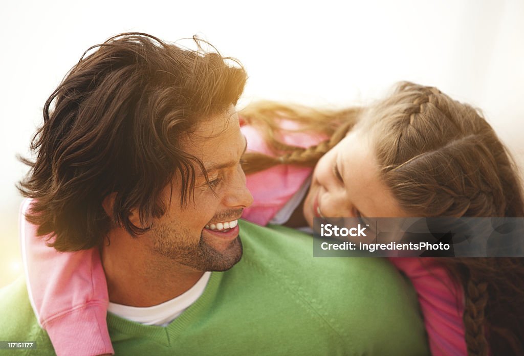 Happy father piggybacking his smiling cute daugther on the beach. Happy father piggybacking his smiling and very happy cute daugther on the beach. Very warm and positive atmosphere. Father Stock Photo