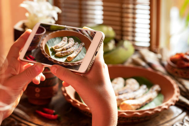 tecnologia, comendo e povos conceito-mãos com smartphone. turista fotografando comida oriental no restaurante do hotel. banana frita plátanos e souce - indian girls audio - fotografias e filmes do acervo