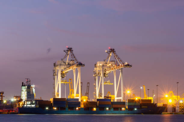 istock Cargo cranes in industrial port at twilight, Transportation and shipping logistics loading dock terminal. 1171512156