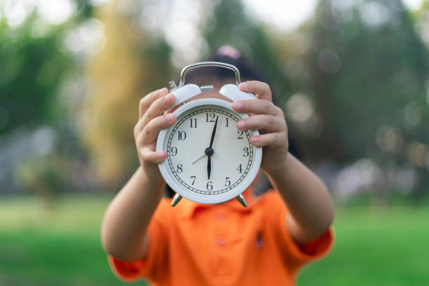 Cute little girl holding an clock