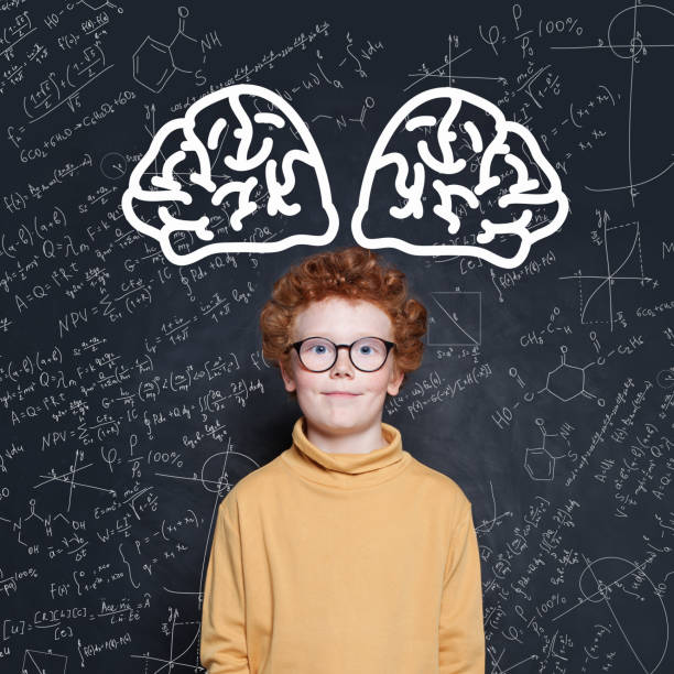 istock Kid boy with red hair standing against blackboard with science formulas 1171514902