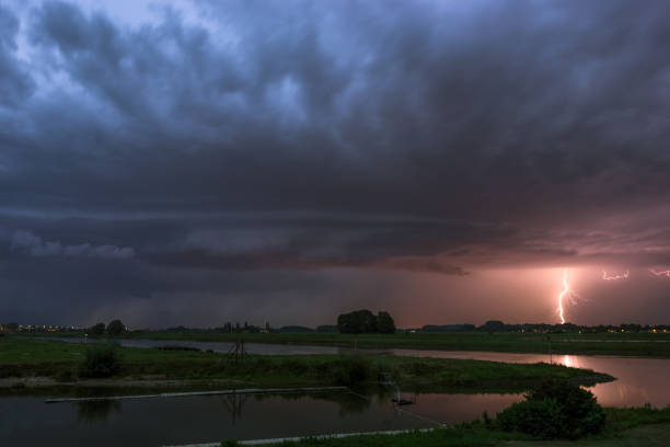 istock Shelfcloud and lightning from a severe thunderstorm near a river at dusk 1171515732