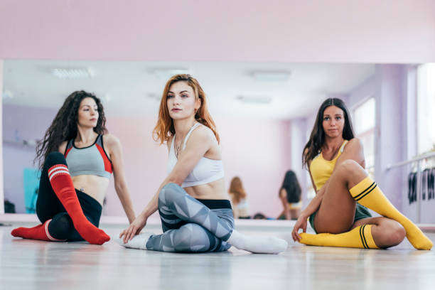 istock Young women sitting in dance studio legs crossed 1171522444
