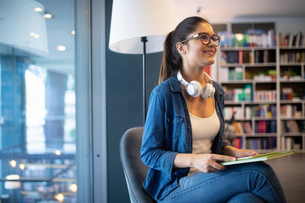 istock College woman studying at the library looking happy 1171525385