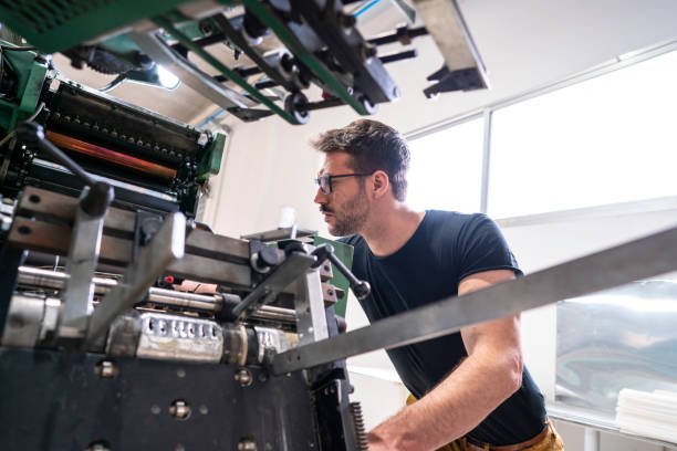 смещение принтер человек с 2 цвета принтера - young men printing plant printing press factory стоковые фото и изображения