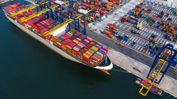 istock Container ship freight shipping containers box at the docks, Aerial view stack of containers in a container ship at deep sea port. 1171526933