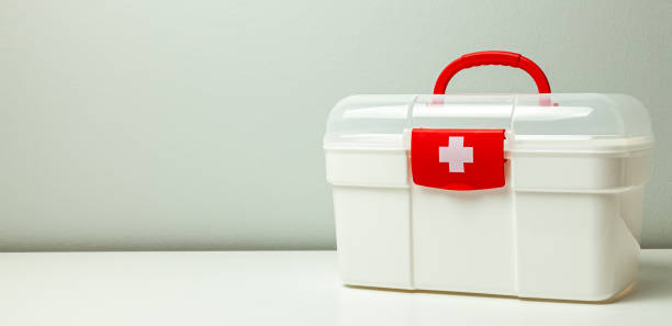 istock First Aid Kit. White box with a cross and a red clasp on a gray background 1171527439