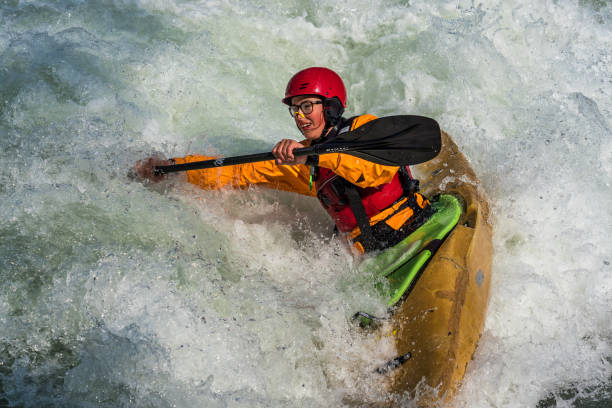 whitewater kayak training on the eiskanal in augsburg. a guy in a kayak sails on the eiskanal in augsburg germany - wildwasserkanufahren stock-fotos und bilder