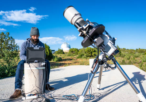 Astronomer connecting telescope and computer Astronomer connecting photo telescope and computer before night comes in daytime astronomer photos stock pictures, royalty-free photos & images