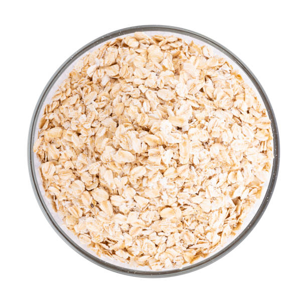 istock Oat flakes pile in bowl on white background 1171537183