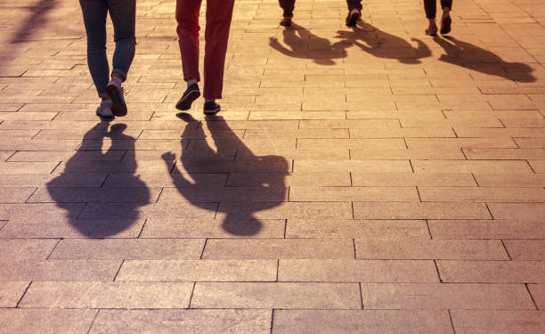 人々の影とシルエット、夕日の間の都市、通りを歩く人々。 - foot long ストックフォトと画像